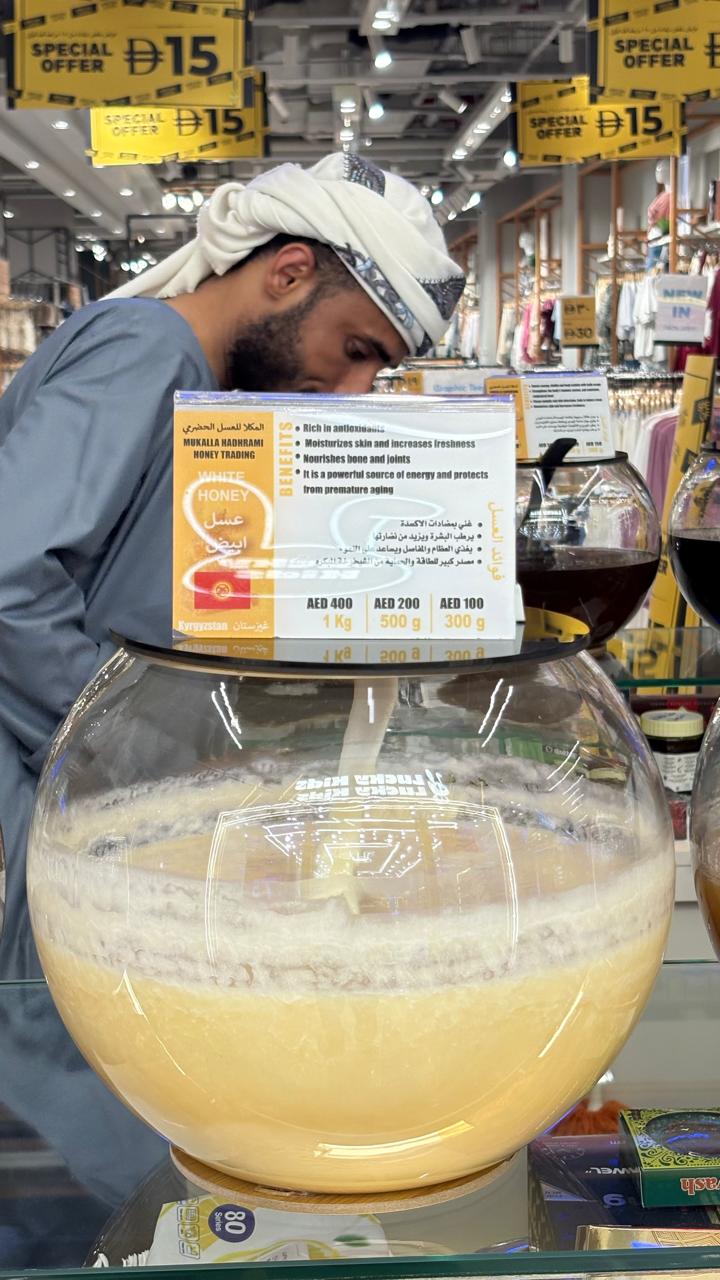 Kyrgyzstan white honey in a large spherical glass jar with creamy ivory texture and branded label.